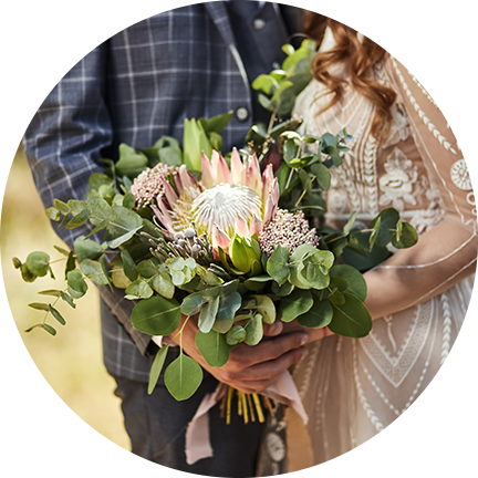 Bride holding a beautiful bouquet with her groom at Fairbridge Village