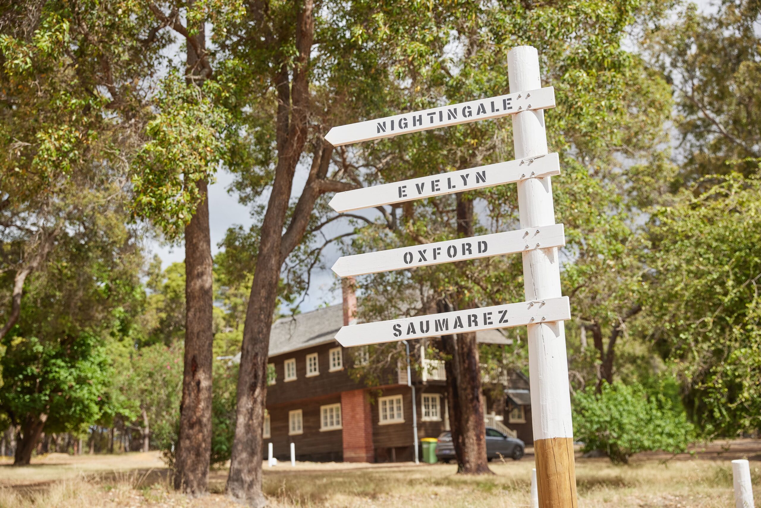 A directional sign in front of Fairbridge Village accommodation, guiding visitors for school camps and activities