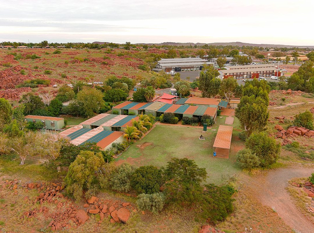 Aerial view of vibrant red rock formations in the scenic landscape of Dampier Camp at Fairbridge, showcasing its beauty